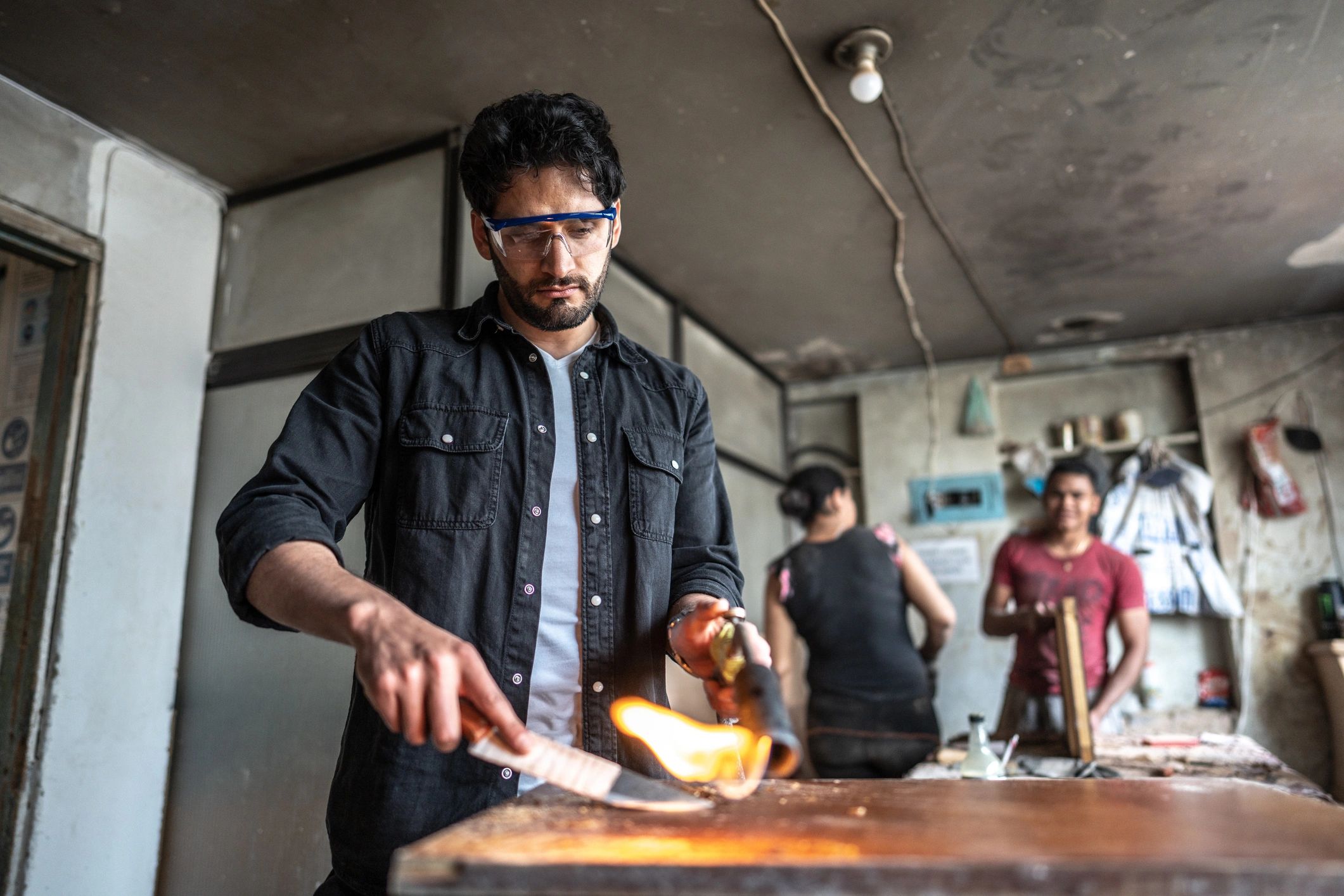 Technician working with a torch in a workshop setting