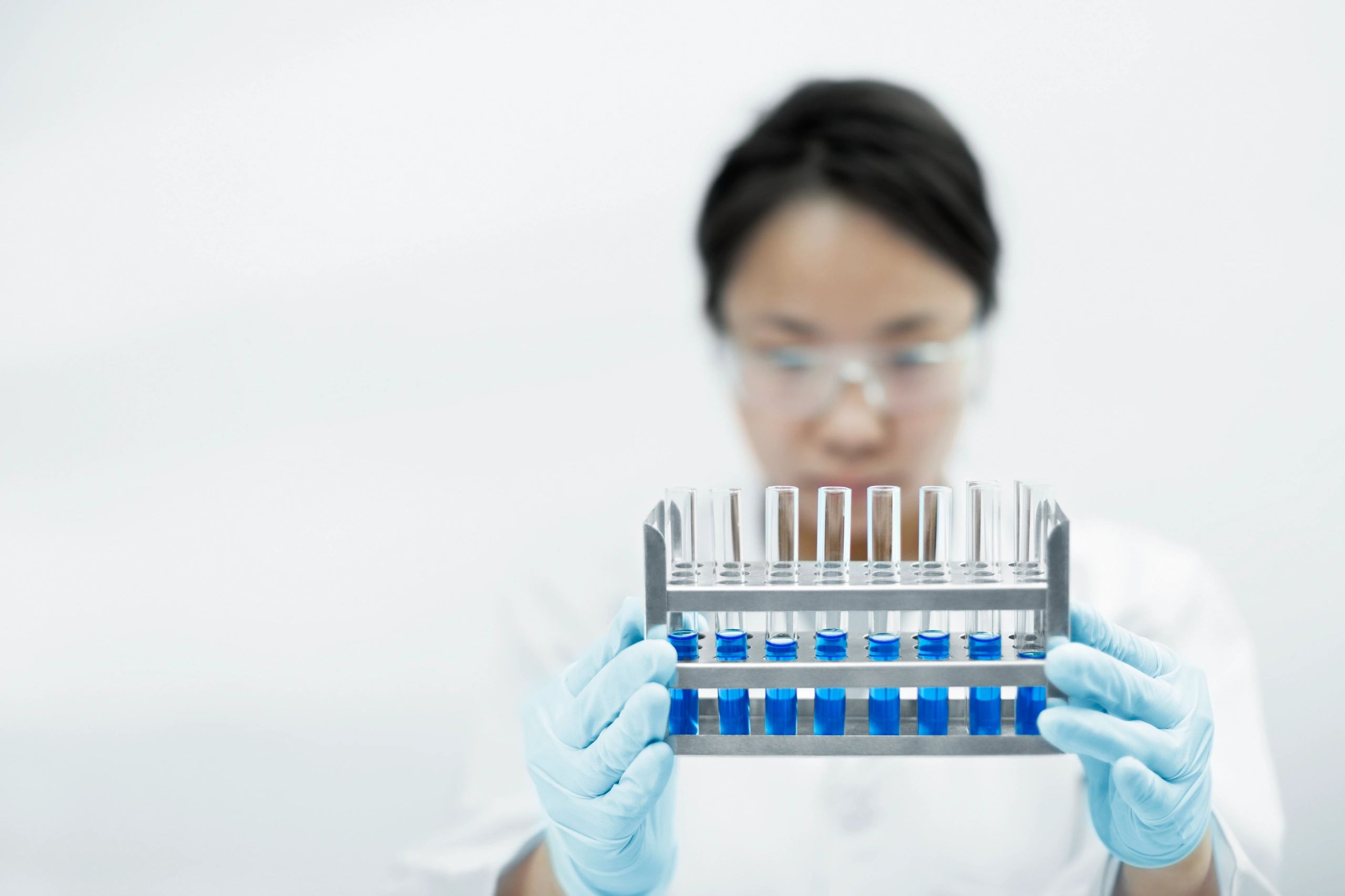Scientist holding test tubes with colored solutions