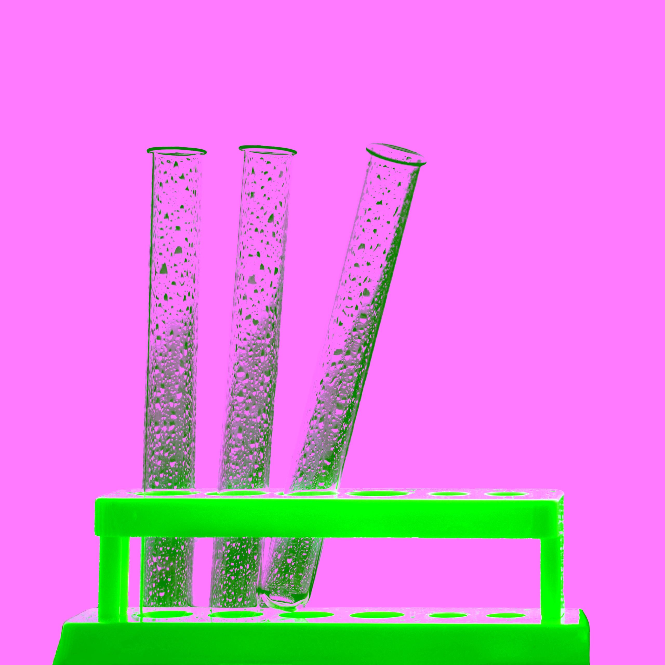 Test tube rack with assorted tubes on a white background